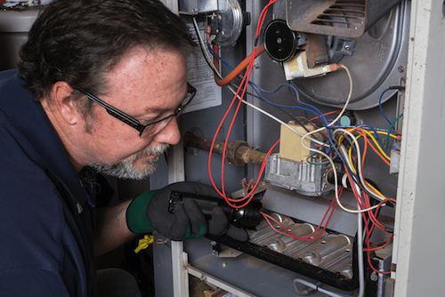a technician repairing a heating and cooling system